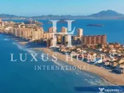 O casă mare, cu terasă, piscină și terasă pe acoperiș, situată aproape de mare