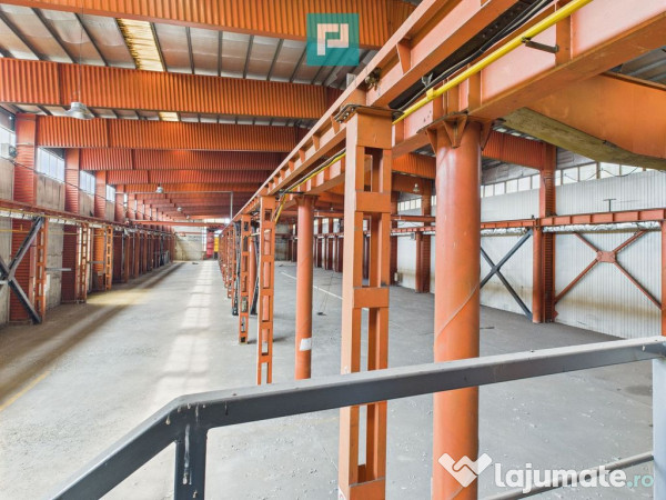 Hală industrială cu pod rulant și parcare betonată 